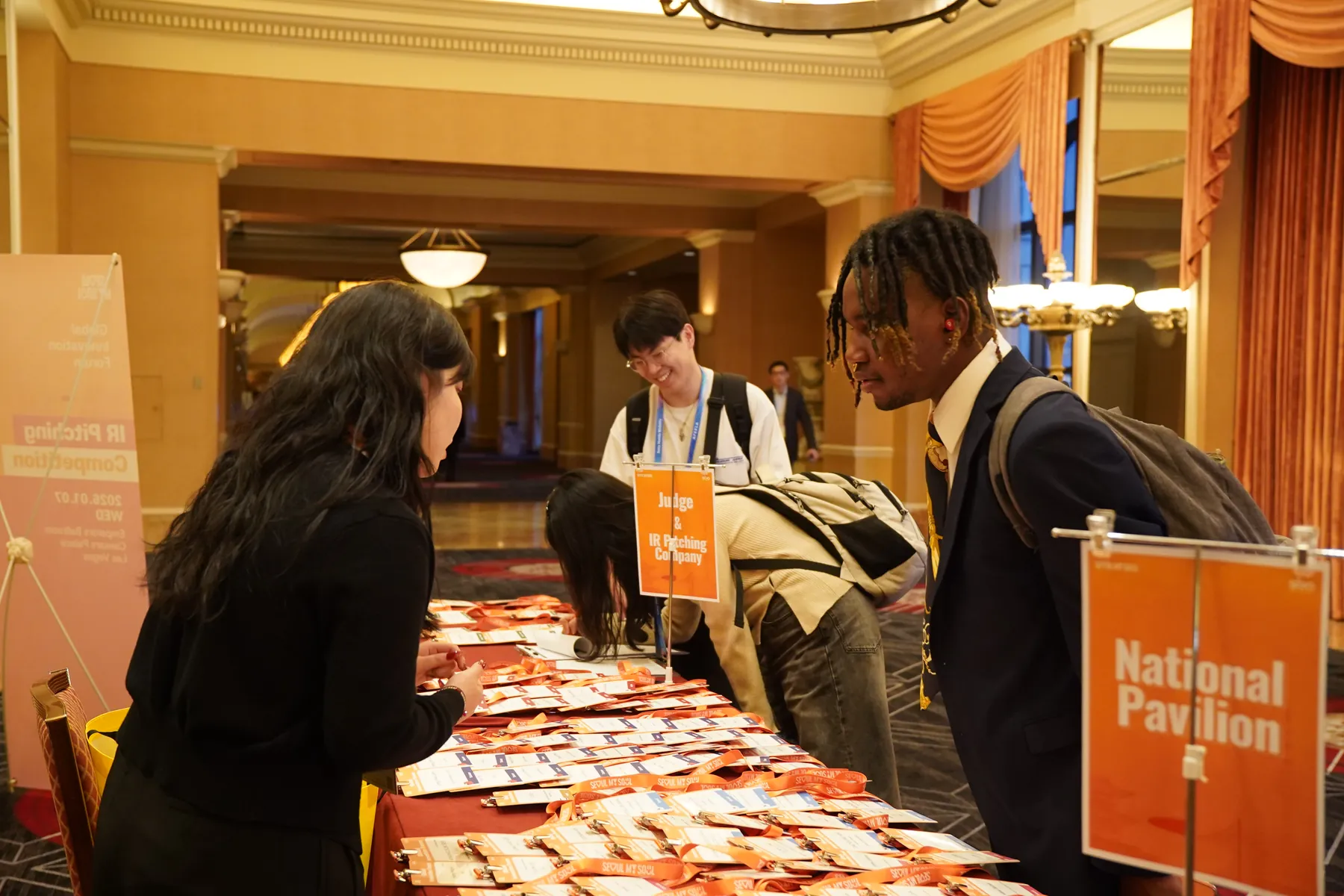 Attendees pick up badges at the National Pavilion check-in table