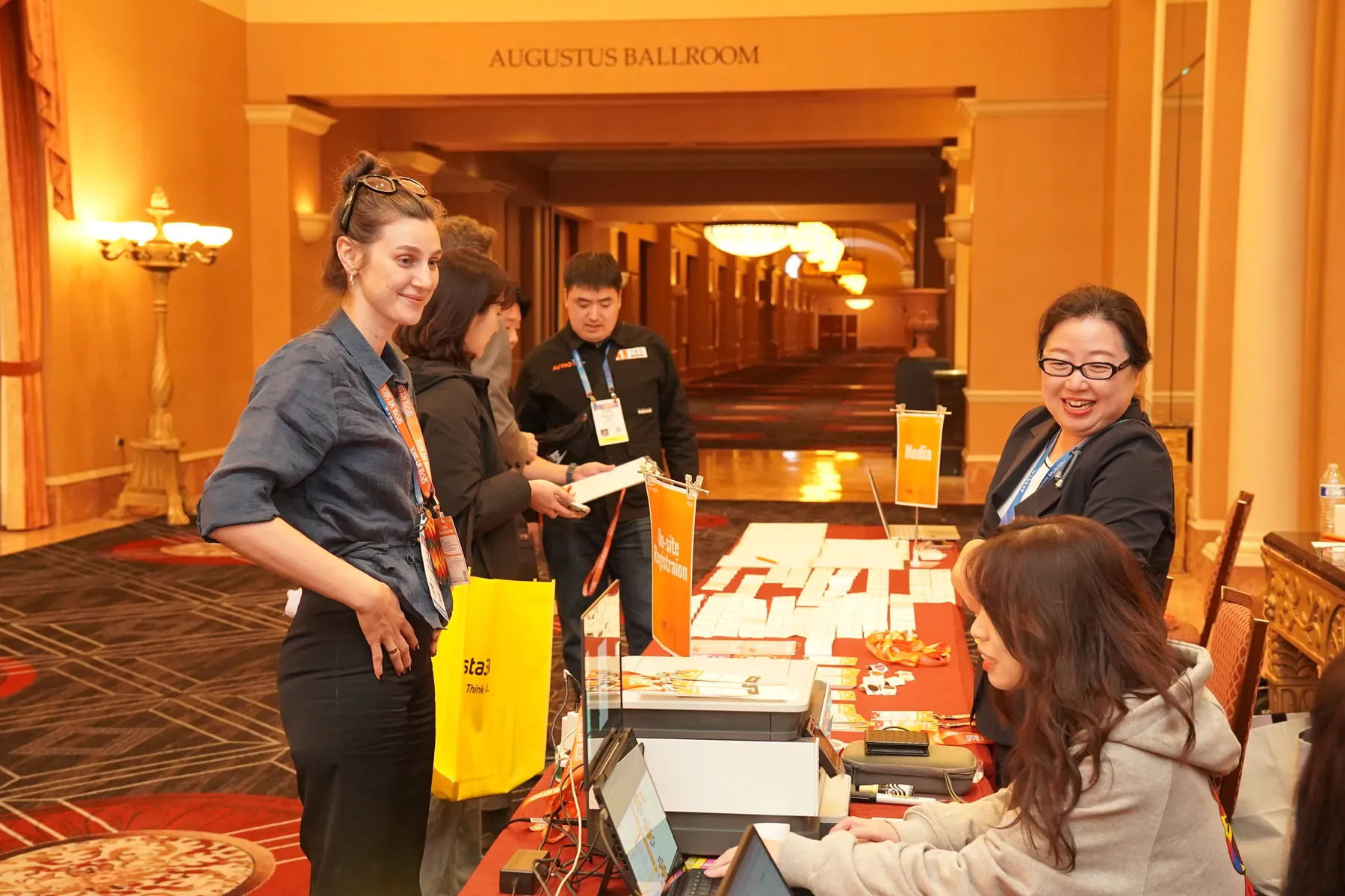 The registration team welcomes guests outside the Augustus Ballroom