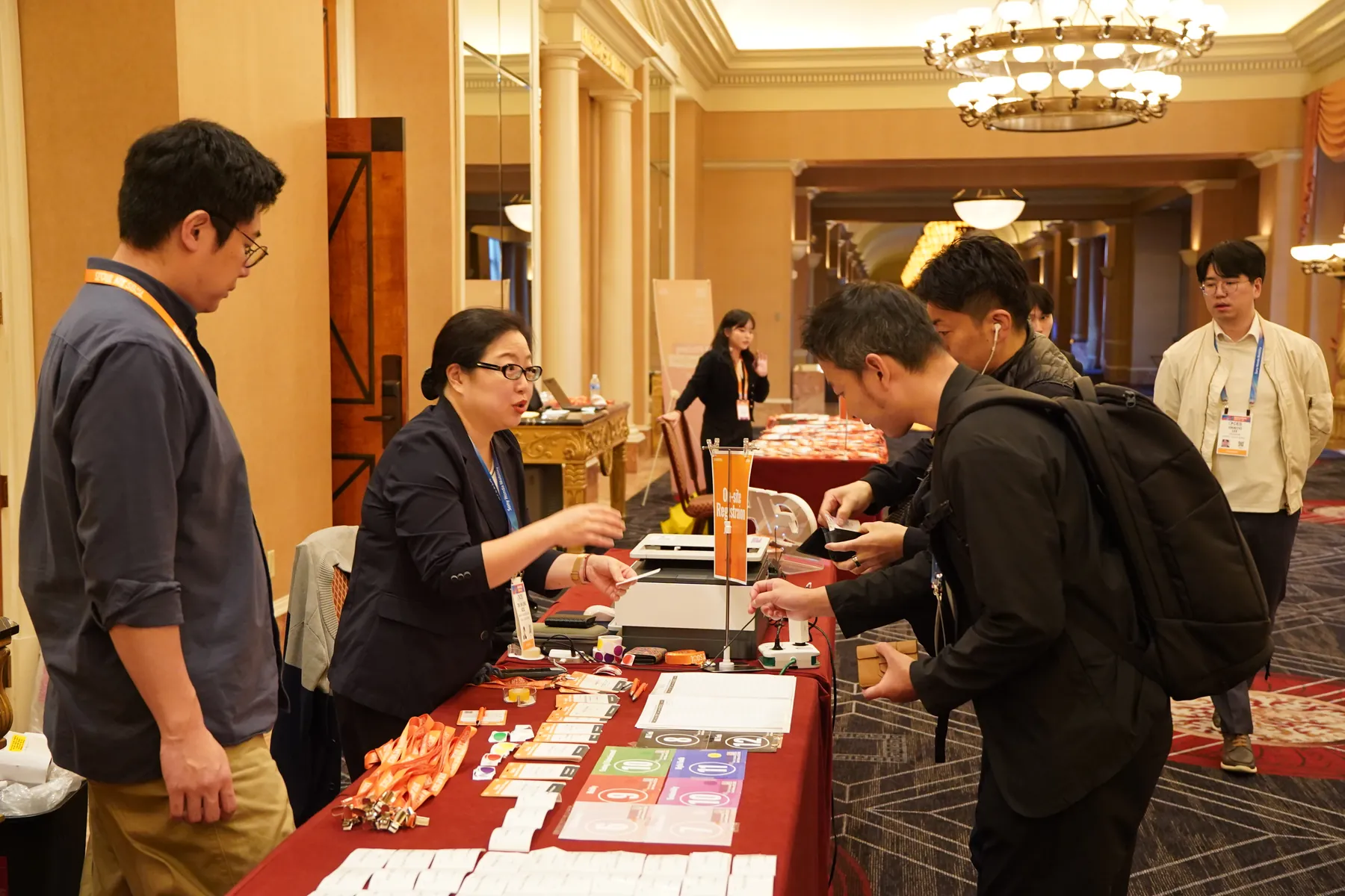 Guests collect lanyards and programs at the reception table