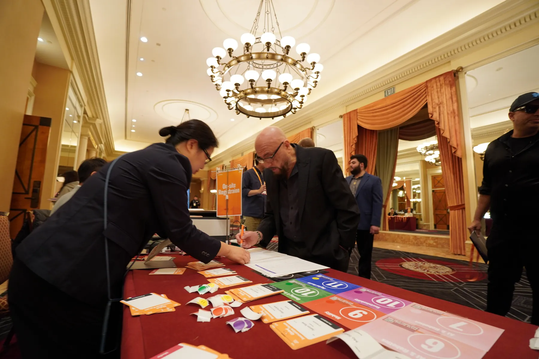 A guest signs in at the welcome table before the sessions begin
